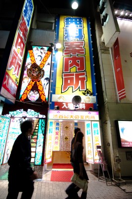 Pedestrians pass a "free information center" on Shibuya's Dogenzaka.