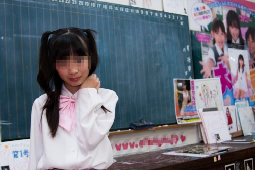A 10-year-old "junior idol" poses for a photo at a bookshop in Akihabara. Fans who buy a girl's DVD get complementary tickets to events where they can meet the idols and take their photos. Photo by Sarah Noorbakhsh