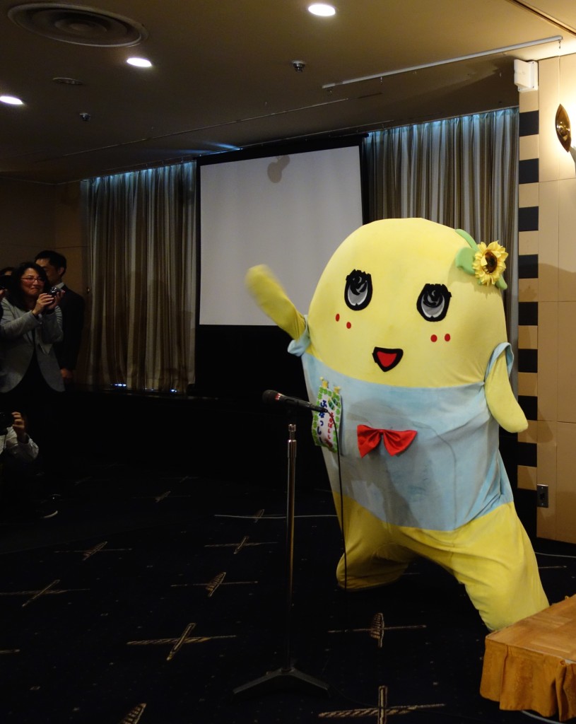 "Funassyi-chan, How do you feel about getting rid of Japan's peace constitution? Funassyi: "That's a really difficult question and I don't want to answer...but in all things I desire peace." Later appears to flash the peace sign. Hard to tell because pear fairies don't have fingers. 