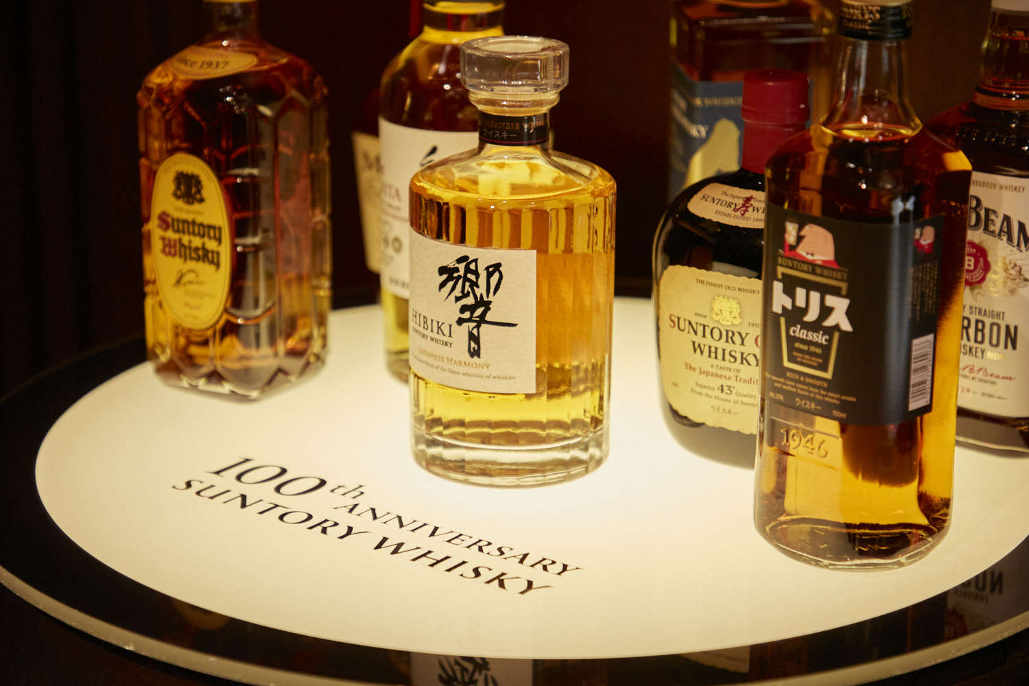 photo of suntory whiskey bottles on a table that says 100th anniversary suntory whiskey